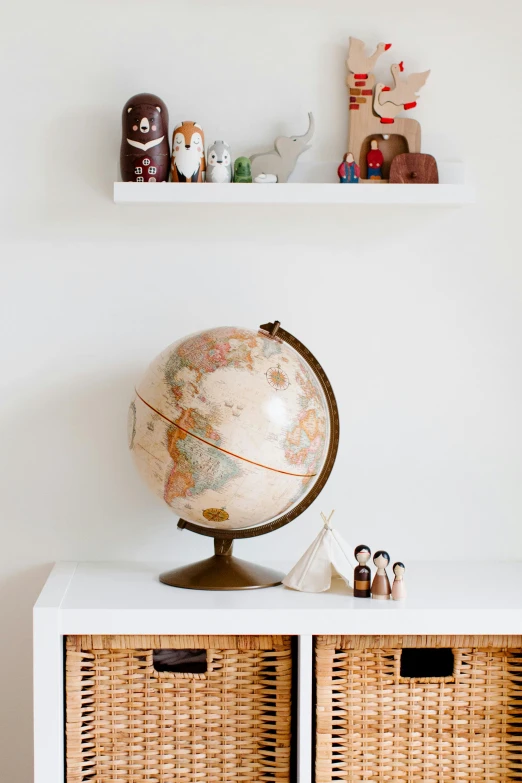 a white cabinet with wicker baskets on top of it, a picture, by Juan O'Gorman, trending on unsplash, large globe, children's toy, jar on a shelf, hero shot