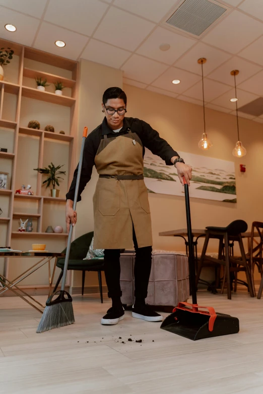 a woman sweeping the floor with a broom, by Julia Pishtar, happening, starbucks aprons and visors, asian male, thumbnail, non-binary