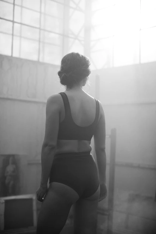 a black and white photo of a woman in a gym, inspired by Peter Lindbergh, bauhaus, medium format. soft light, back view. nuri iyem, 8 k film still, :: morning