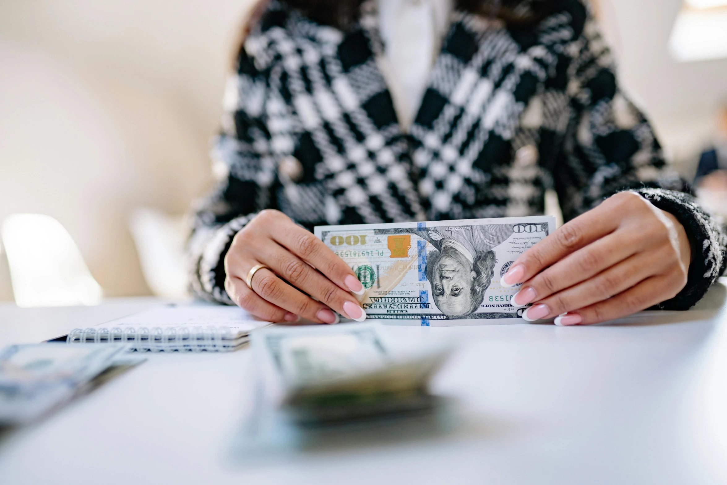 a woman sitting at a table holding a stack of money, by Julia Pishtar, pexels contest winner, 🚀🌈🤩, bottom angle, realistic », 1450