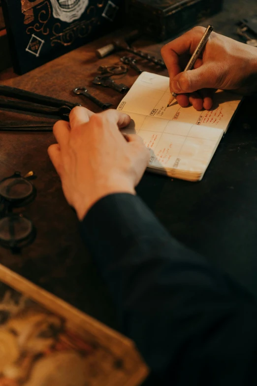 a person sitting at a table writing on a piece of paper, an engraving, pexels contest winner, arts and crafts movement, leather straps, gunsmithing, instagram story, inspect in inventory image