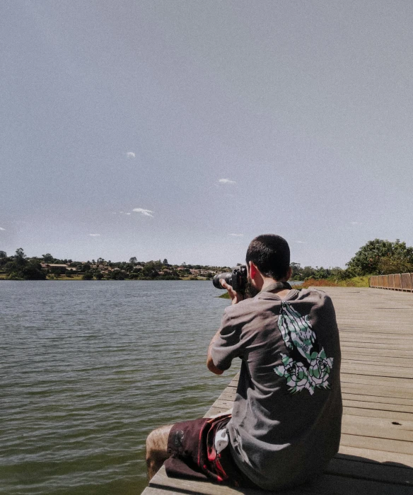 a man sitting on a dock taking a picture, a picture, by Bascove, unsplash, realism, on a hot australian day, low quality print, pewdiepie selfie at a bridge, lake view