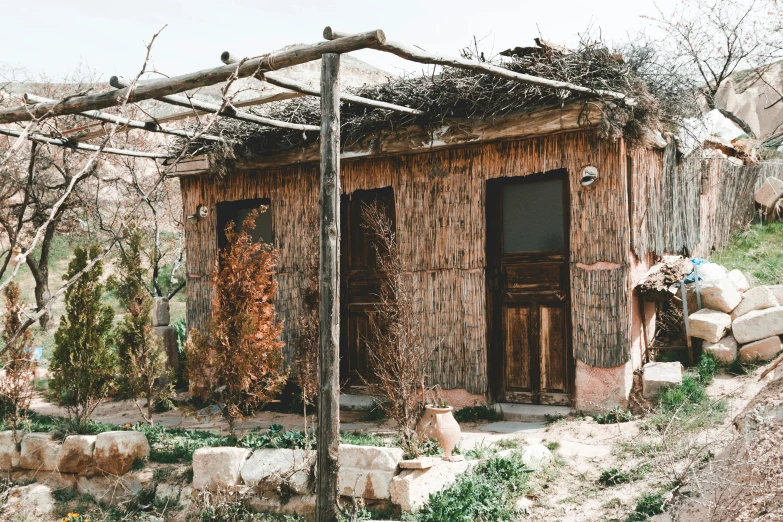 a small wooden building sitting on top of a hill, unsplash, renaissance, sukkot, dried vines, 90s photo, rammed earth courtyard