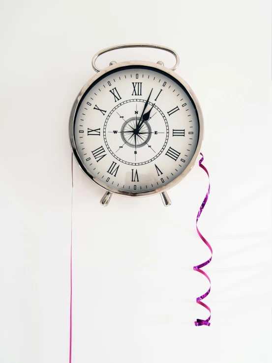 a clock hanging from the side of a wall, streamers, set against a white background, 2019 trending photo