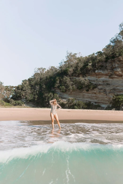 a woman standing on a surfboard in the ocean, by Arabella Rankin, minimalism, in australia, margot robbie on the beach, girl walking in a canyon, bulli