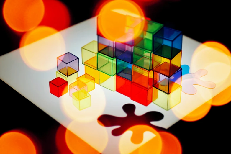 a group of cubes sitting on top of a table, a raytraced image, flickr, interactive art, vibrant backlit, shapes and colours, square shapes, bokeh light from top