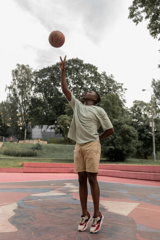 a man standing on top of a basketball court holding a basketball, by Matija Jama, dribble contest winner, at a park, ( ( dark skin ) ), 15081959 21121991 01012000 4k