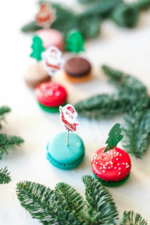 a bunch of macarons sitting on top of a table, santa, diecut, spruce trees, medium close shot