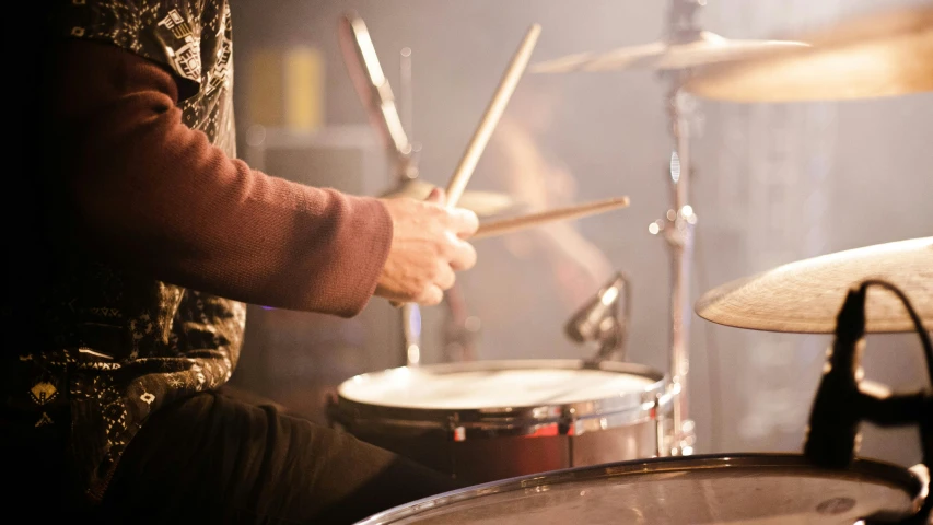 a man playing drums in a dark room, pexels, warm light, composite, illustration:.4, lachlan bailey