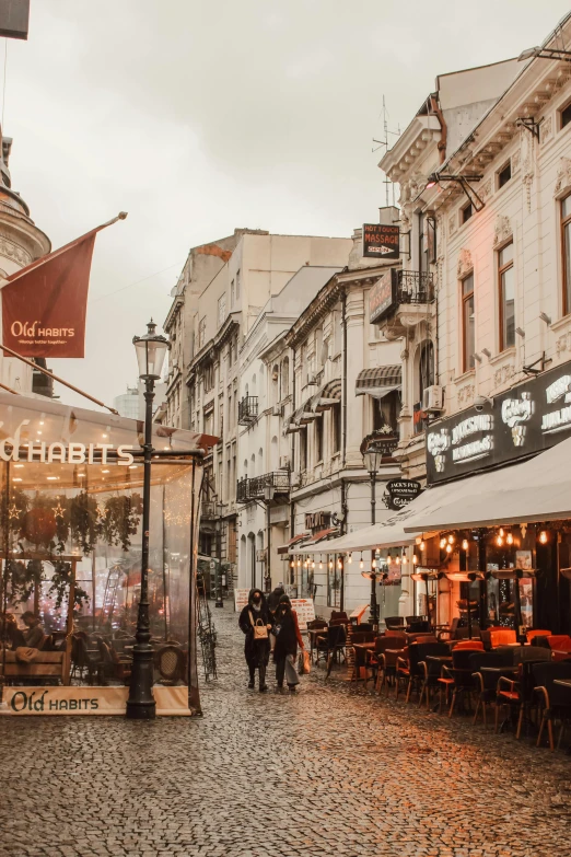 a couple of people walking down a cobblestone street, a photo, pexels contest winner, restaurant in background, rostov city, canopies, commercial banner