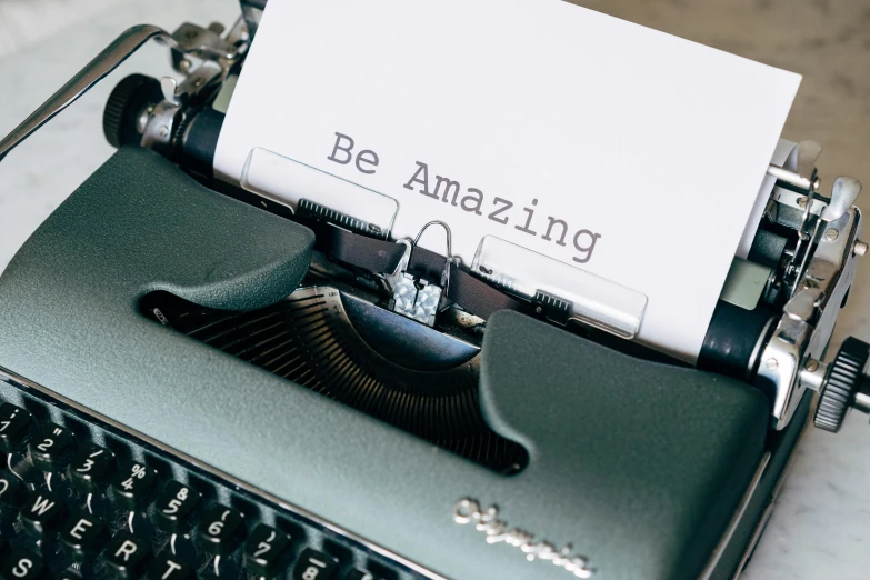 a close up of a typewriter with a paper on it, a picture, by Emma Andijewska, trending on pexels, bursting with positive energy, lettering, amazement, thumbnail