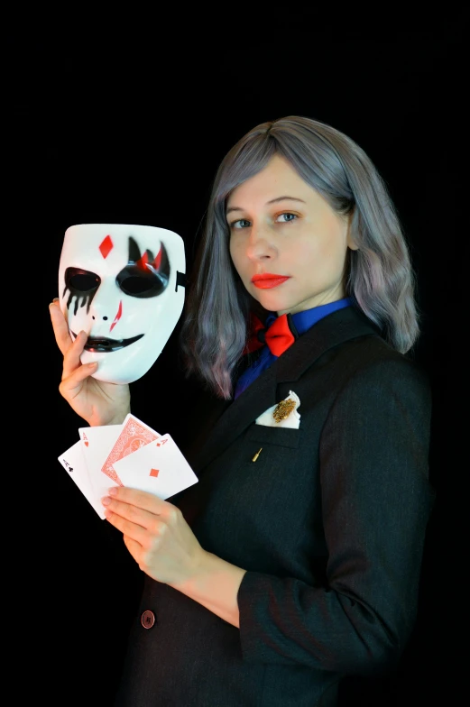 a woman holding a mask and playing cards, featured on reddit, antipodeans, wearing a black suit, cosplayer, avatar image, discord profile picture