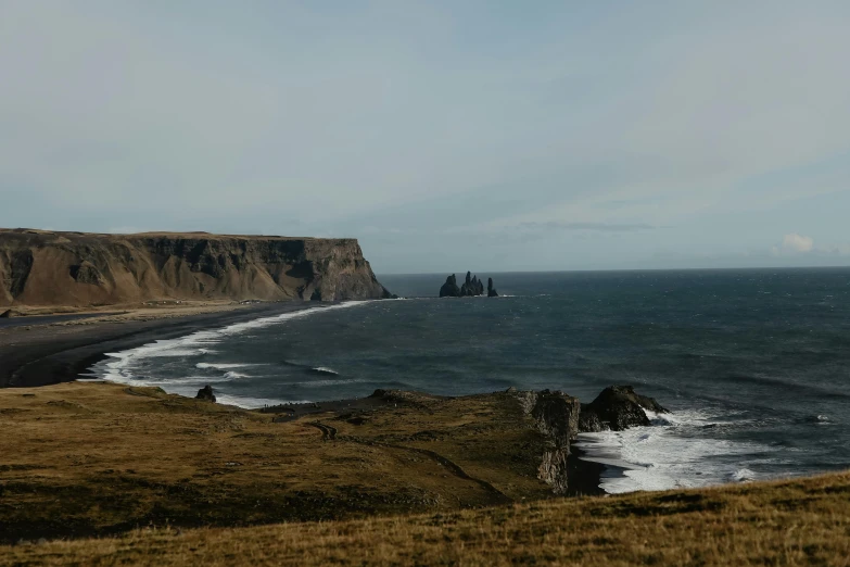 a large body of water sitting on top of a lush green hillside, by Matthias Stom, pexels contest winner, coastal cliffs, obsidian towers in the distance, haafingar hold, background image