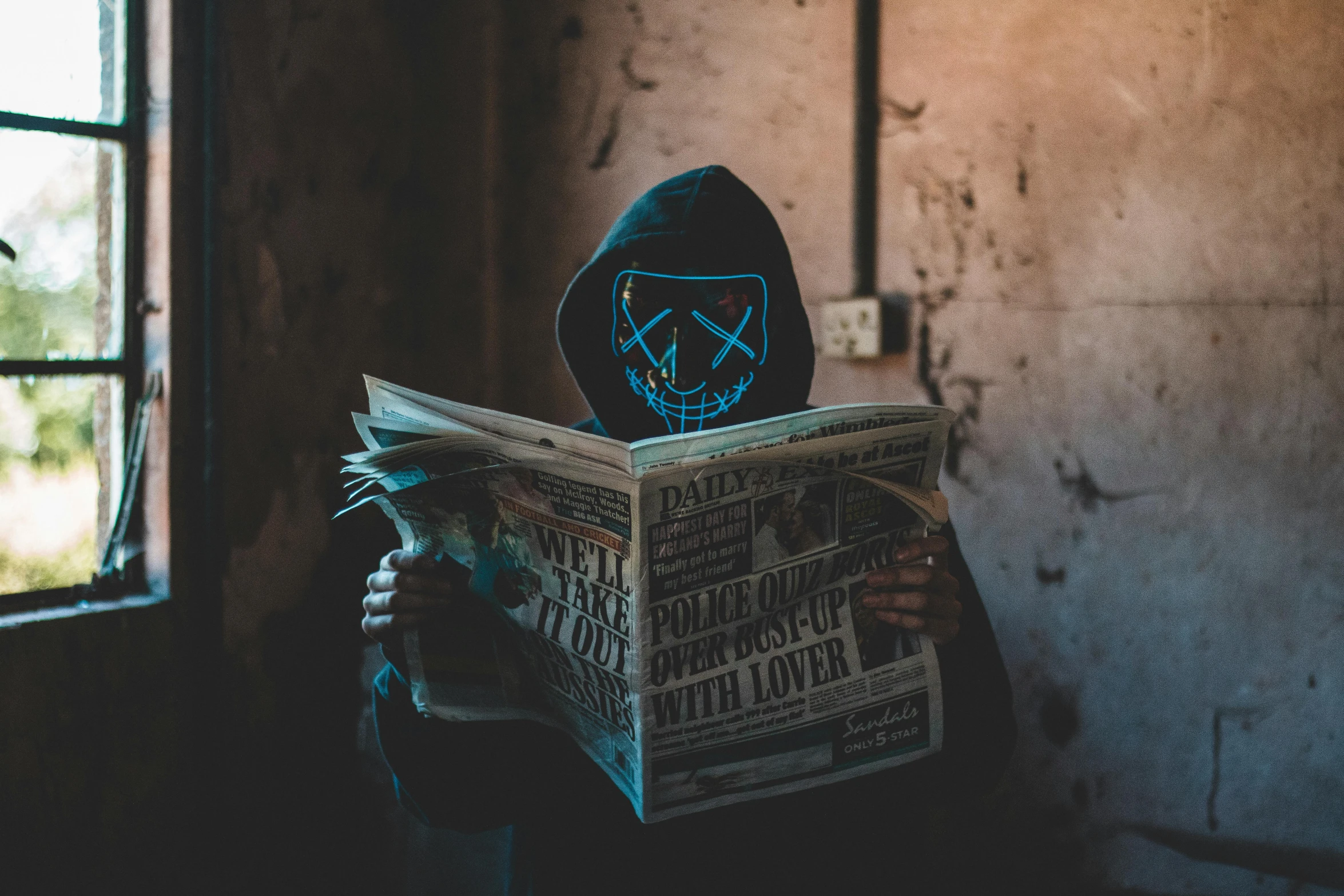 a person wearing a mask reading a newspaper, an album cover, pexels contest winner, graffiti, creepy lighting, glowing blue, discord profile picture, hooded skull