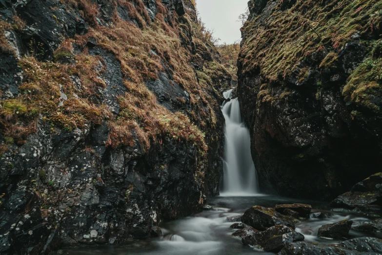 a waterfall in the middle of a rocky gorge, by Jesper Knudsen, pexels contest winner, hurufiyya, thumbnail, high quality photo, grey, gungnir