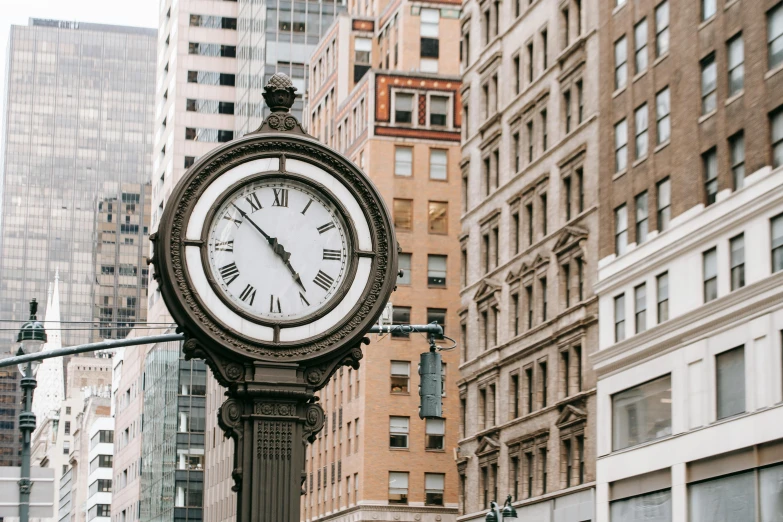 a clock on a pole in the middle of a city, by Carey Morris, unsplash, art nouveau, square, ny, background image