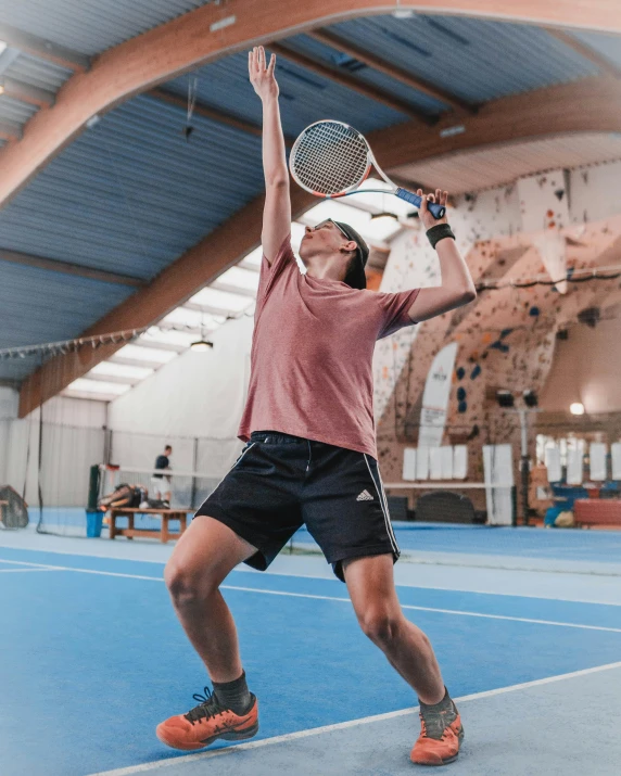 a man holding a tennis racquet on top of a tennis court, happening, profile image, high arched ceiling, thumbnail, train with maroon