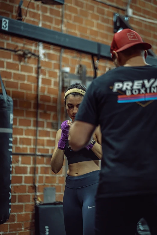 a man and a woman boxing in a gym, by Robbie Trevino, precision, profile image, freya, training bra