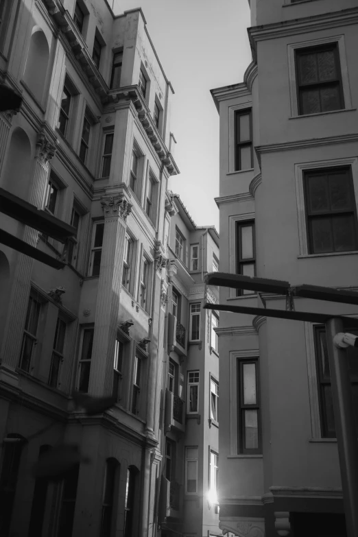 a black and white photo of a city street, a black and white photo, by Niyazi Selimoglu, baroque, istanbul, buildings, low angle photograph, cinematic style photograph