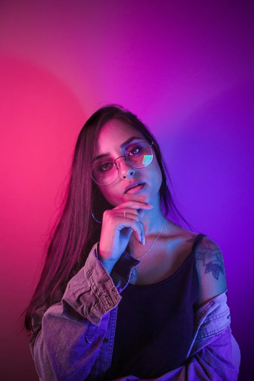 a woman wearing glasses and a denim jacket, inspired by Elsa Bleda, trending on pexels, holography, bright pink purple lights, thoughtful pose, purple and red colors, 2019 trending photo