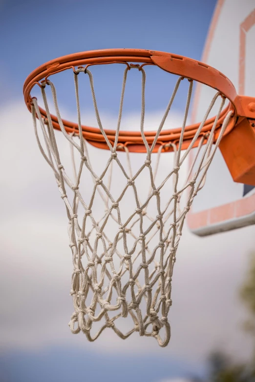 a close up of a basketball net with a blue sky in the background, profile image