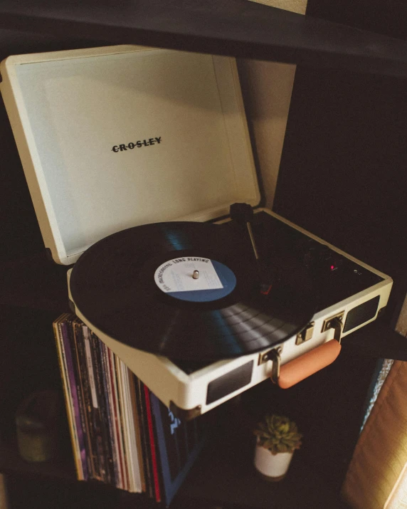 a record player sitting on top of a shelf, an album cover, by Everett Warner, trending on pexels, happening, in suitcase, late night, glossy white, high angle shot