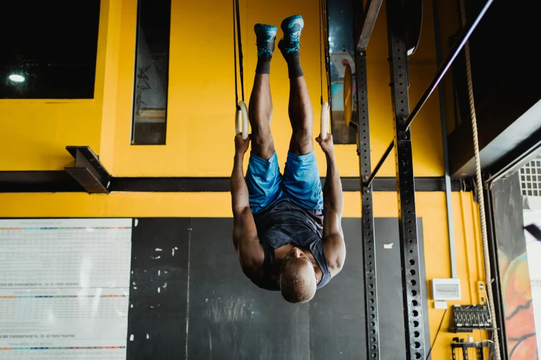a man doing a handstand in a gym, a portrait, pexels contest winner, hurufiyya, hanging veins, on a yellow canva, athletic crossfit build, emmanuel shiru