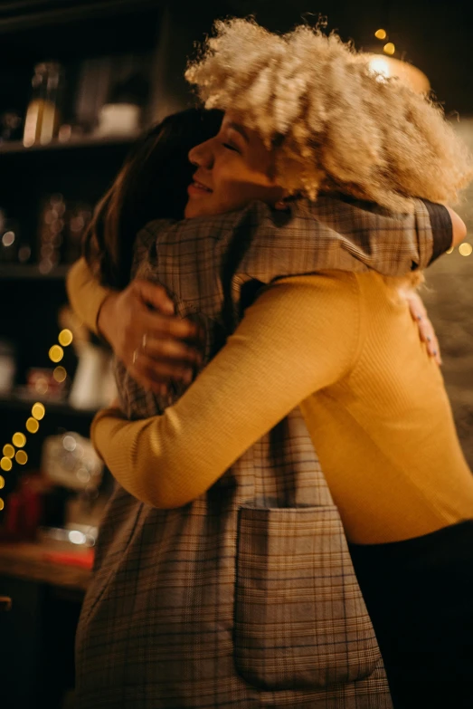 a couple of people that are hugging each other, pexels, happening, cozy lights, woman holding another woman, high quality film still, her friend