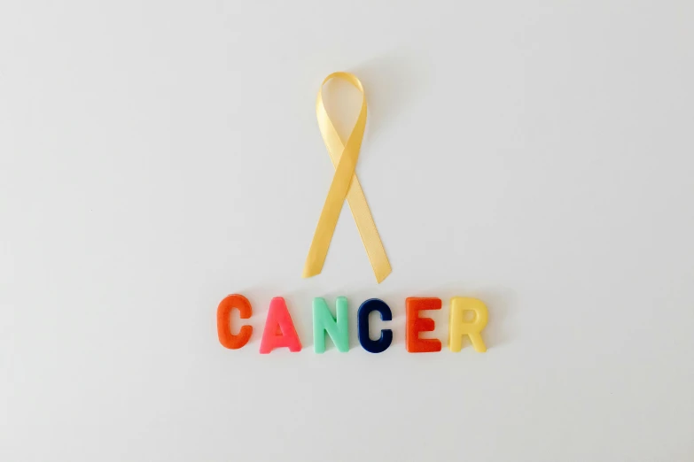 the word cancer spelled with a yellow ribbon, pexels, visual art, colorful signs, 1990s, family photo, mri