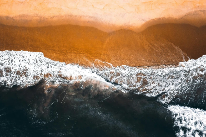 a large body of water next to a sandy beach, by Daniel Lieske, pexels contest winner, black and orange colour palette, ocean simulation, ocean spray, a high angle shot