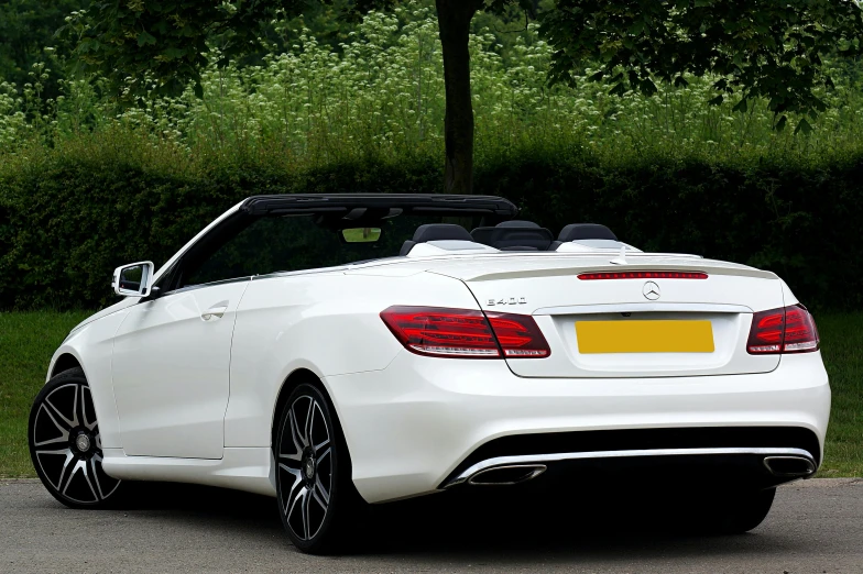 a white mercedes convertible parked on the side of the road, pexels contest winner, rear facing, plain background, highly polished, half body cropping