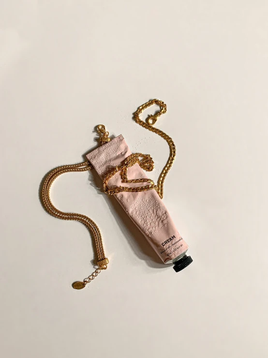 a bottle of perfume sitting on top of a chain, けもの, ammo bandolier, ((pink)), upcycled