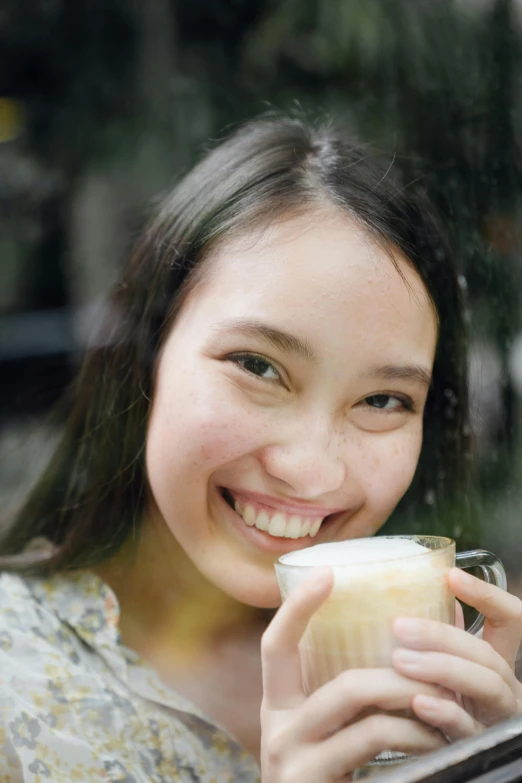 a close up of a person holding a cup of coffee, a picture, inspired by Tan Ting-pho, renaissance, smile on her face, headshot profile picture, jakarta, 21 years old