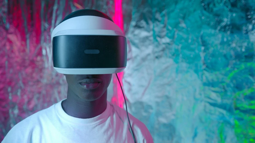 a man in a white shirt wearing a virtual reality headset, a hologram, pexels, afrofuturism, black teenage boy, shot with sony alpha 1 camera, film still promotional image, vibrant light