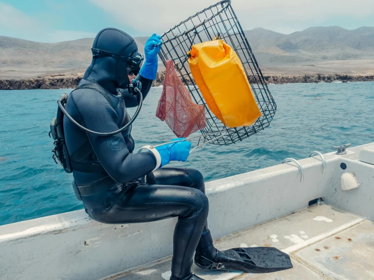 a man in a wet suit sitting on a boat, deep sea creatures, carrying a tray, orange balaclava, taken in 2 0 2 0