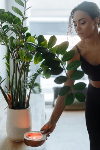 a woman standing in front of a potted plant, trending on unsplash, happening, cottagecore!! fitness body, detailed ambient lighting, indoor scene, athletic muscle tone
