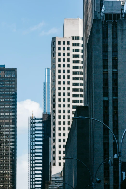 a city street filled with lots of tall buildings, by William Berra, pexels contest winner, modernism, tall minimalist skyscrapers, chicago, commercial banner, three - quarter view