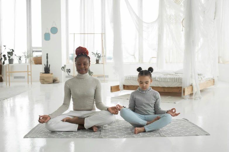 a couple of women sitting on top of a rug, trending on pexels, meditating pose, child, white, good posture