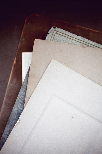 a pile of papers sitting on top of a table, an album cover, inspired by Rachel Whiteread, unsplash, private press, beautiful aged and rustic finish, picture frames, vintage closeup photograph, 1790