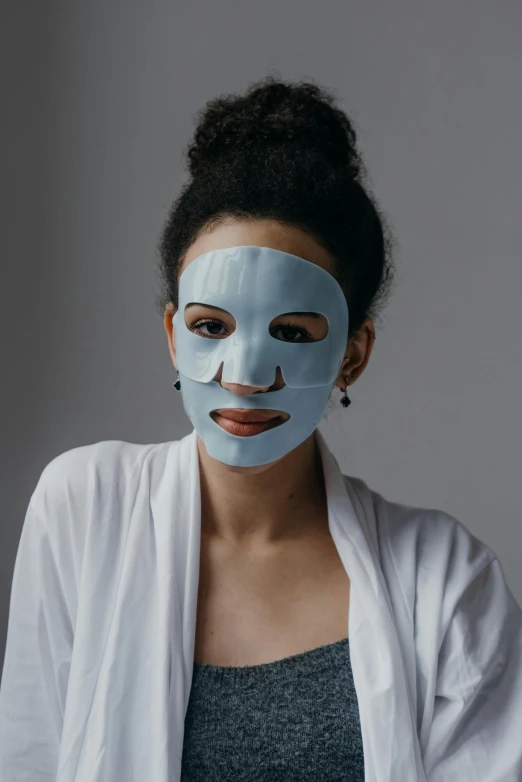 a woman with a sheet mask on her face, an album cover, trending on pexels, blue gray, synthetic bio skin, ready to model, cut out