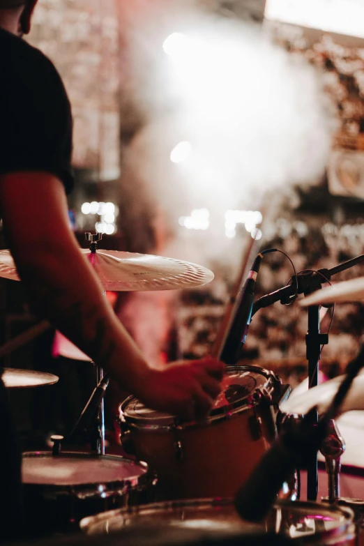 a man playing drums in front of a microphone, pexels contest winner, happening, background bar, manly, resin, indoor setting