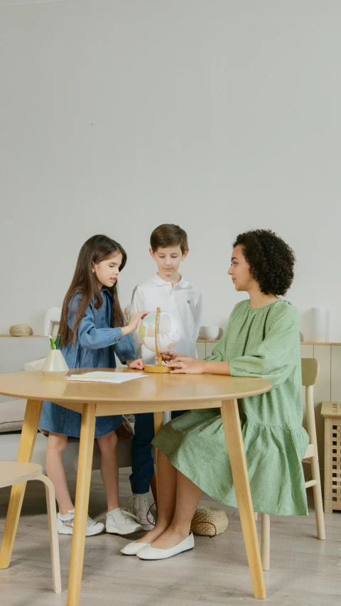 a woman sitting at a table with two children, pexels, conceptual art, wooden furniture, low quality photo, pestle, thumbnail