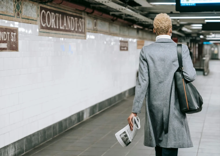 a man is walking down a subway platform, private press, curly blonde hair | d & d, confidant, fan favorite, going gray