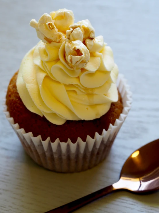 a cupcake sitting on top of a table next to a spoon, profile image, up-close, full product shot, hr ginger