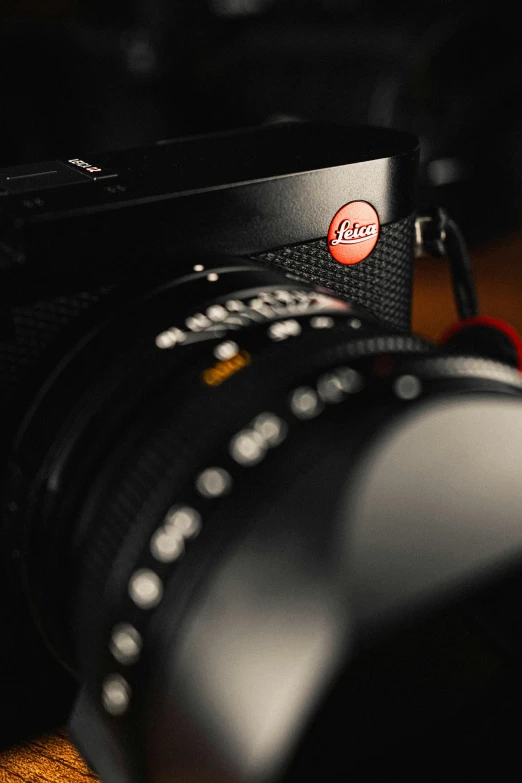 a camera sitting on top of a wooden table, red dot, black steel with red trim, icon, cinematic photograph