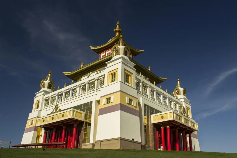 a large building sitting on top of a lush green hillside, inspired by Yang Buzhi, art nouveau, colourful biomorphic temple, carrington, golden detailing, delightful surroundings