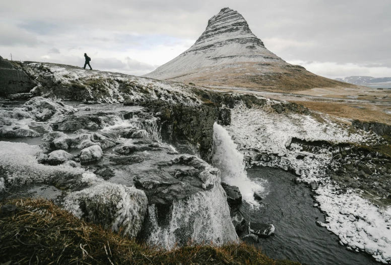 a man standing on top of a snow covered mountain, by Daniel Seghers, pexels contest winner, small waterfalls, balaskas, thumbnail, medium format