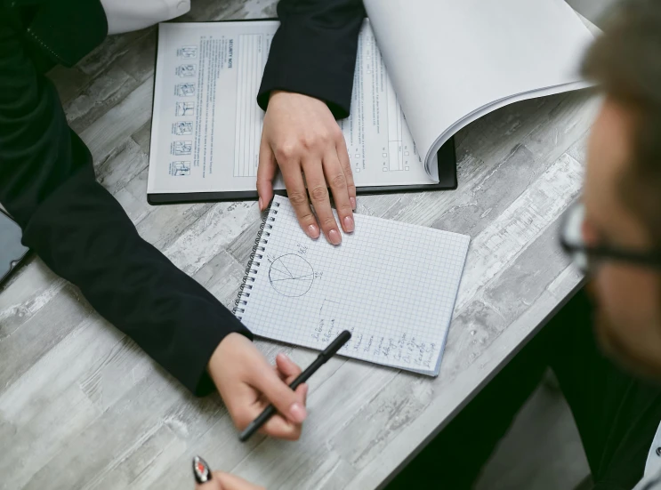 a couple of people that are sitting at a table, trending on pexels, analytical art, notebook, maths, background image, professional closeup photo