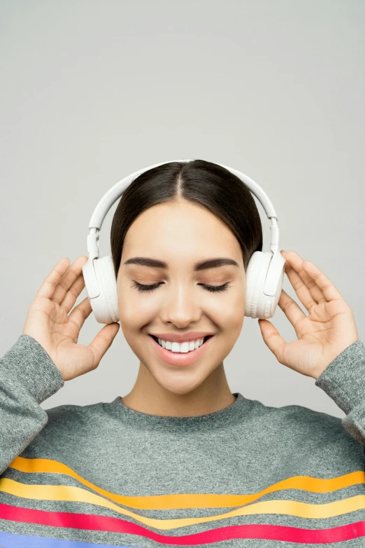 a woman is listening to music with headphones, trending on pexels, on a gray background, uploaded, smiling, large ears