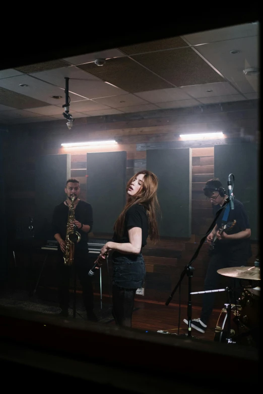 a group of people that are standing in a room, an album cover, unsplash, saxophone, panoramic view of girl, hr ginger, performing a music video